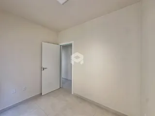 Interior de um ambiente com paredes brancas e piso claro.