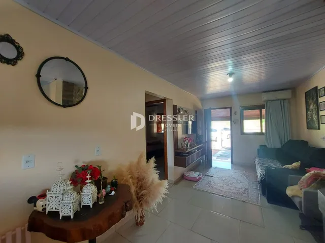 Ambiente interno de uma sala com paredes amarelas e teto de painéis brancos.