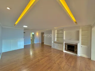 Sala de estar com piso de madeira e teto inclinado em um imóvel em Lajeado.