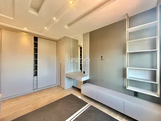 Sala de estar ampla com piso de madeira e armários embutidos.