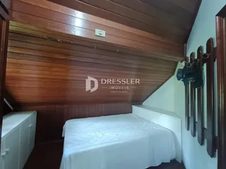 Foto de um quarto com parede de madeira e cama em um imóvel no Brasil.