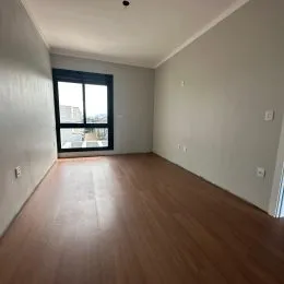 Uma foto de um cômodo interno com piso de madeira e janela.