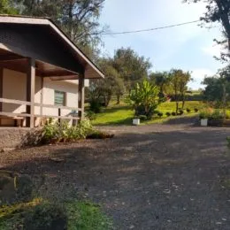 Foto da fachada de uma propriedade com área externa e vegetação.