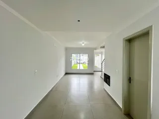 Corredor interno de uma residência com piso de cerâmica e parede branca.