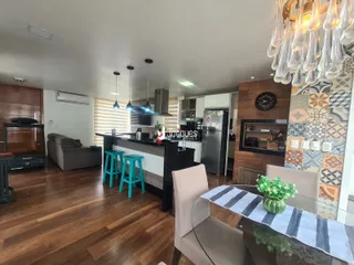 Ambiente moderno de sala de estar com cozinha aberta e piso de madeira.