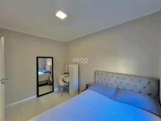Quarto com cama e espelho em ambiente claro.