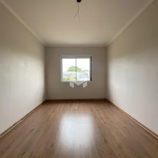 Uma sala de estar com piso de madeira clara e janela.