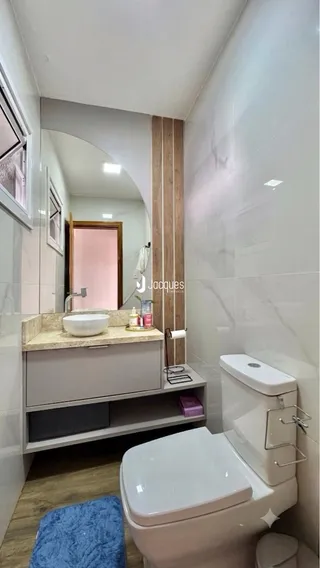 Foto de um banheiro interno com azulejos brancos e louças sanitárias.