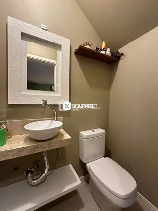 Banheiro com pia e vaso sanitário em uma sala de banho.