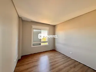Uma sala de estar com piso de madeira e janela.