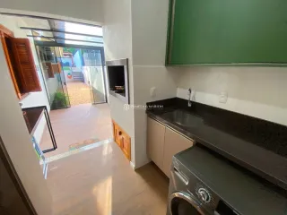 Vista interna de uma sala com porta de vidro que dá acesso a um pátio.