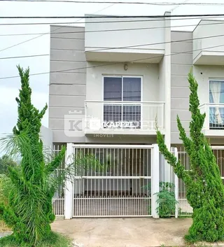 Fachada de um prédio residencial em Lajeado, Brasil, com portão de acesso e vegetação.