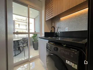 Vista da cozinha com portas de vidro que dão acesso a uma área externa.