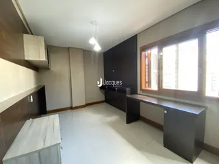 Interior de uma sala com revestimento de madeira e piso claro.