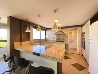 Foto de uma cozinha moderna com bancada e iluminação suspensa.