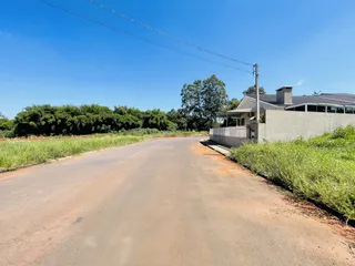 A foto mostra a fachada de uma residência em uma área rural com vegetação densa ao redor.