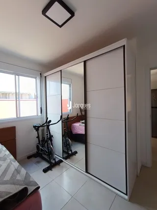 Quarto com porta de vidro e piso de cerâmica.
