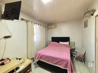 Quarto com cama e janela em uma residência.