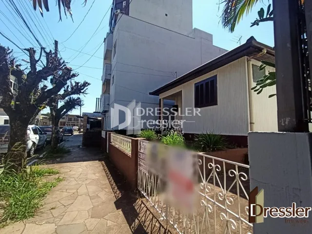 Vista da fachada de uma propriedade com cerca e caminho no exterior.
