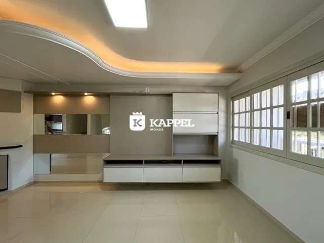 Sala de estar moderna com teto curvo e armários planejados em um imóvel em Lajeado.