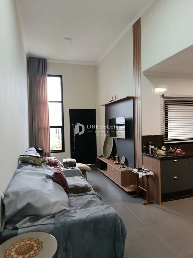 Quarto com cama grande e cortinas em uma sala de estar.