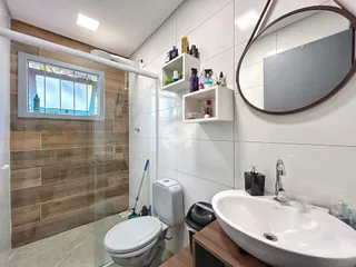 Foto de um banheiro moderno com revestimento de madeira e box de vidro.