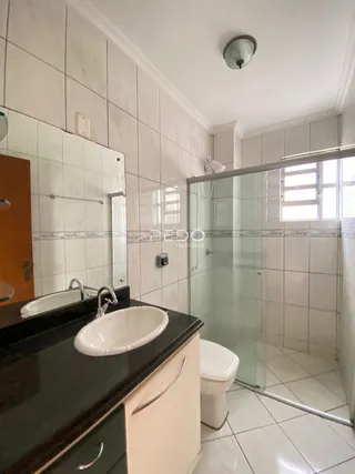 Foto de um banheiro com azulejos brancos e box de vidro.