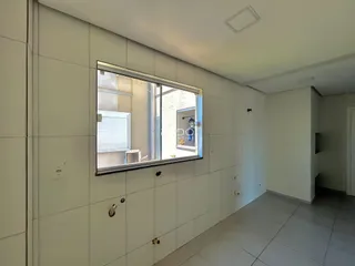 Vista interna de um ambiente com paredes brancas e piso de cerâmica.