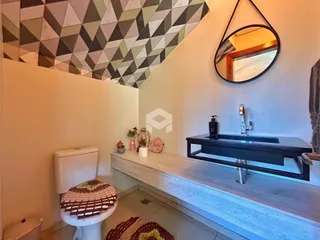 Foto de um banheiro com vaso sanitário e bancada de madeira.