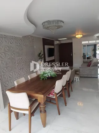 Uma sala de estar com mesa de madeira e cadeiras em um imóvel no Brasil.