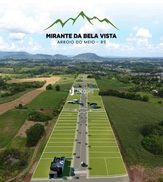 Vista aérea de uma área de terreno com campos e uma estrada no interior.