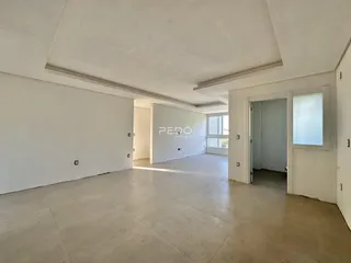 Ambiente interno amplo com paredes brancas e piso de concreto.