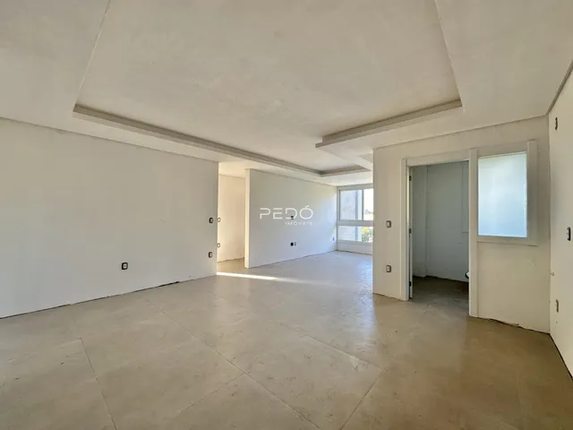 Ambiente interno amplo com paredes brancas e piso de concreto.