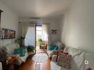 Sala de estar com sofá e televisão em um imóvel no Brasil.