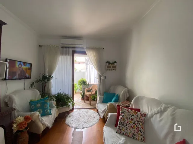 Sala de estar com sofá e televisão em um imóvel no Brasil.