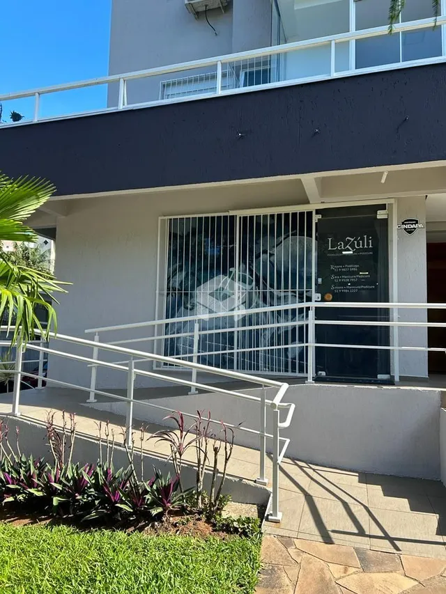 Fachada de um imóvel com varanda e grade de segurança branca.