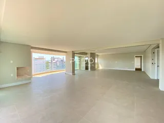 Ambiente interno de uma sala ampla com piso de cerâmica clara.