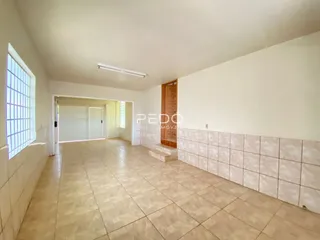 Hall de entrada com piso de cerâmica e paredes brancas.