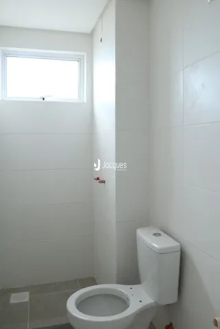 Foto de um banheiro interno com vaso sanitário branco.