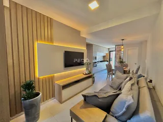 Sala de estar moderna com televisão e sofá em um apartamento.