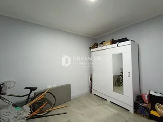 Foto de um cômodo interno com paredes brancas e piso claro.
