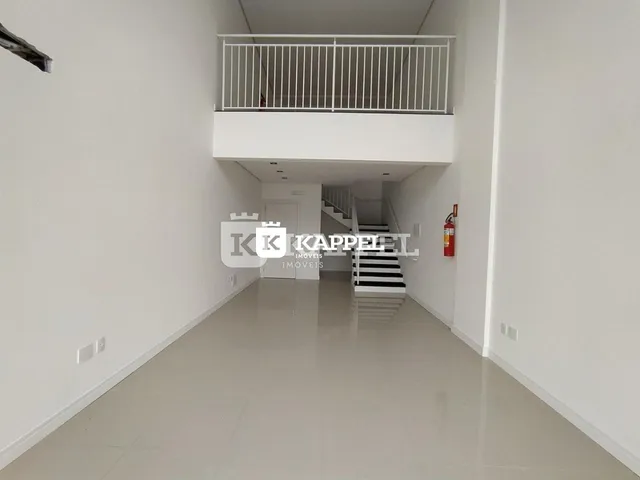 Hall de entrada com escadaria e varanda no interior de um imóvel.