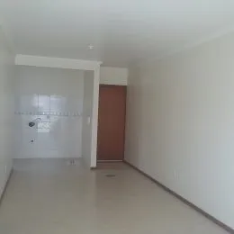 Hall de entrada com paredes brancas e uma porta visível.