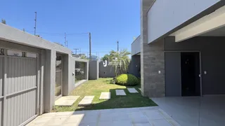 Fachada de uma residência moderna com garagem e jardim.