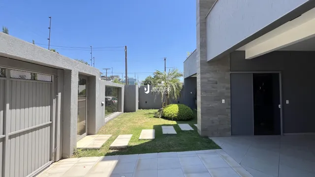 Fachada de uma residência moderna com garagem e jardim.