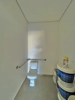A foto mostra um banheiro com vaso sanitário e um suporte de toalha.