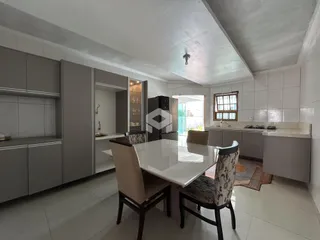 Ambiente de cozinha e jantar moderno com armários em tom de cinza claro.