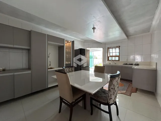Ambiente de cozinha e jantar moderno com armários em tom de cinza claro.