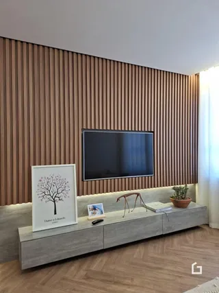 Sala de estar com parede de madeira e televisão.