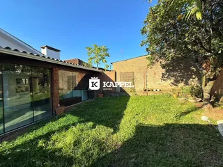Fachada de uma residência com jardim gramado sob céu azul.